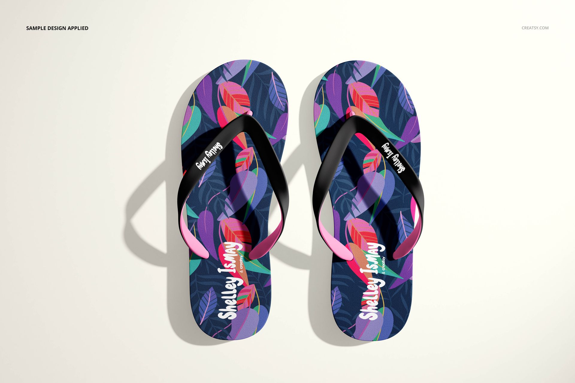 Pair of flip flops mockup featuring vibrant multicolor leaf design and black straps, shown from above on a plain surface.