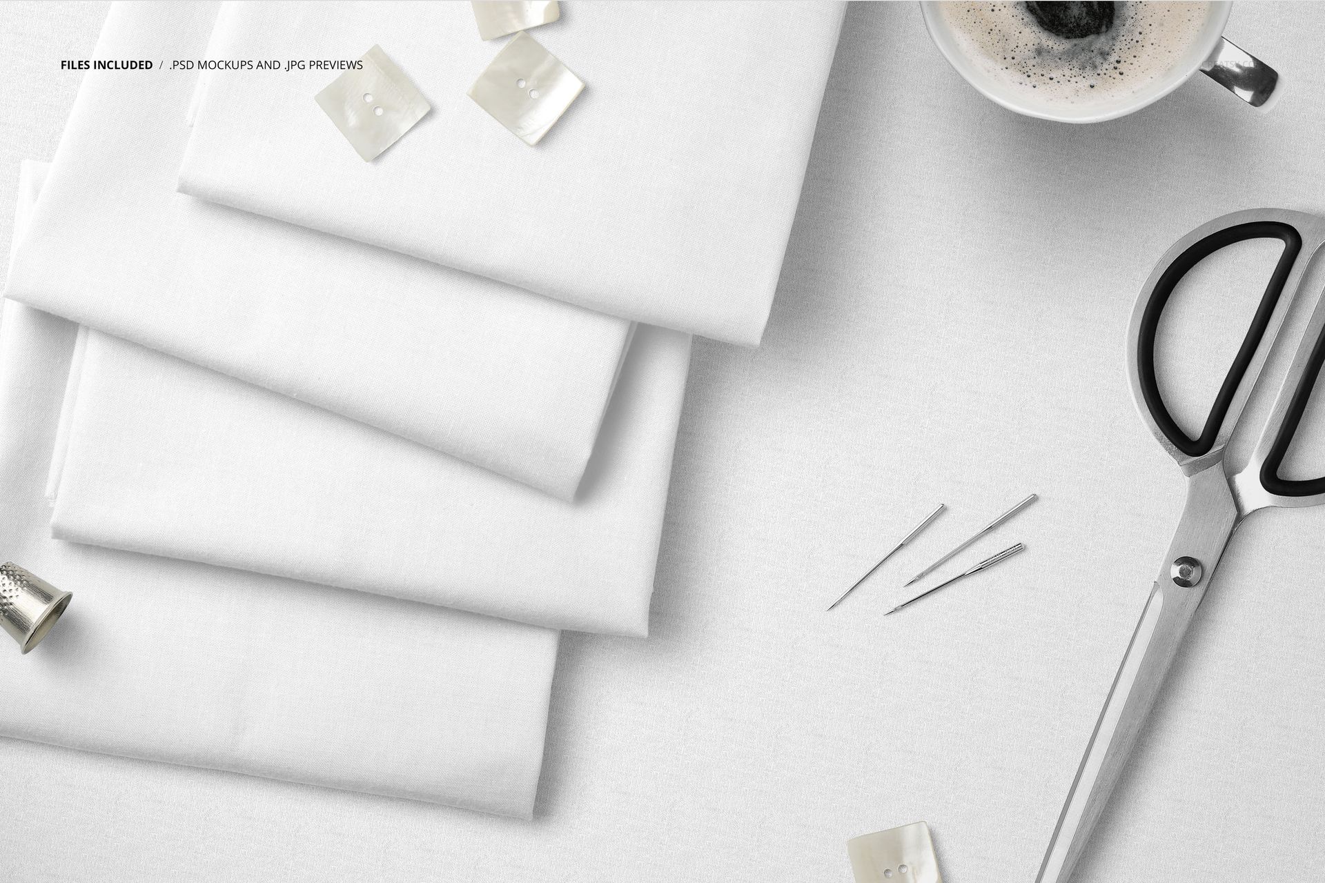 White textile mockup featuring folded fabric layers, metal scissors, sewing pins, buttons, and a coffee cup.