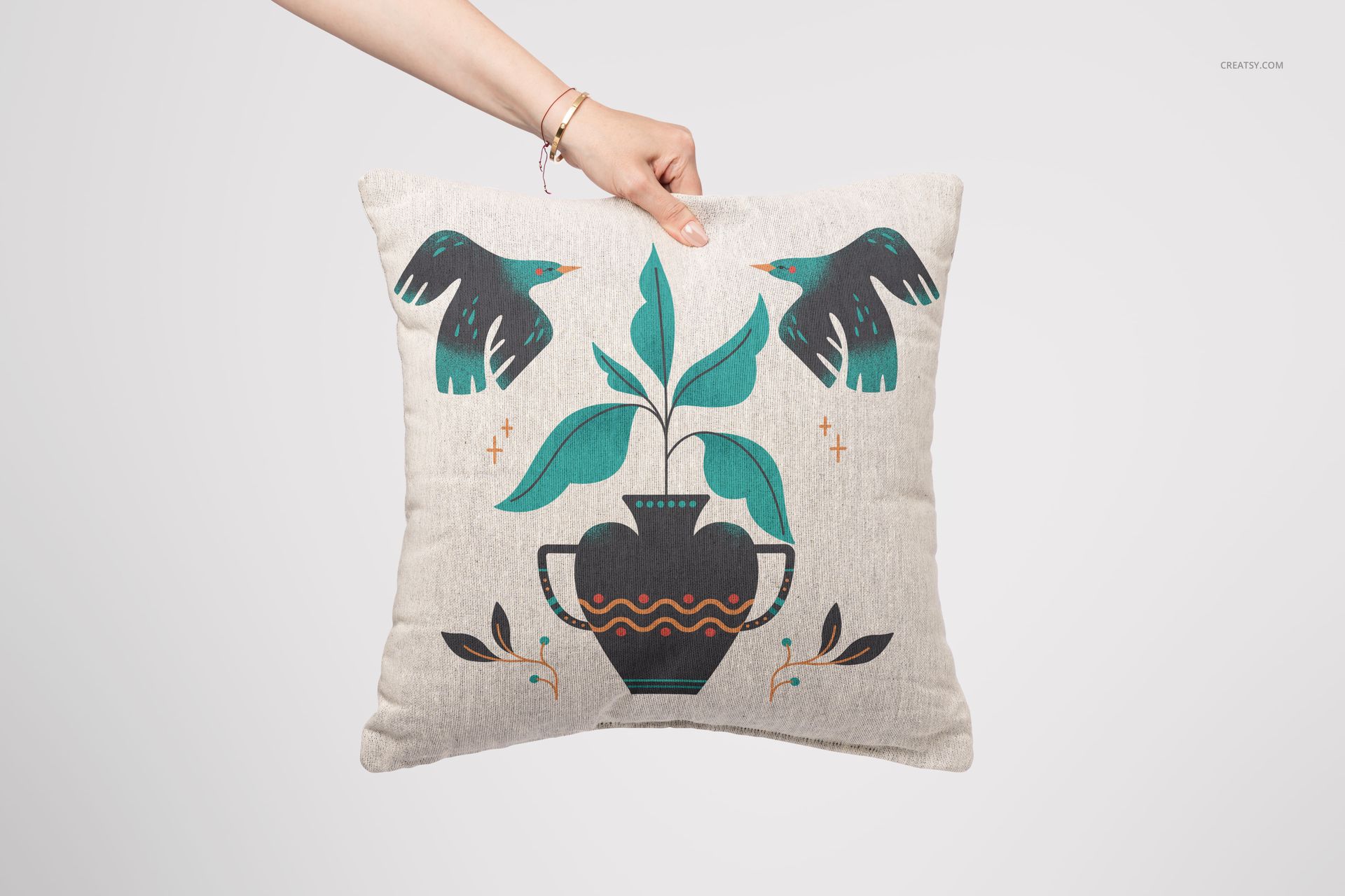 Front view of a 45x45cm woven pillow mockup featuring a vase, plant, and stylized birds on neutral fabric.