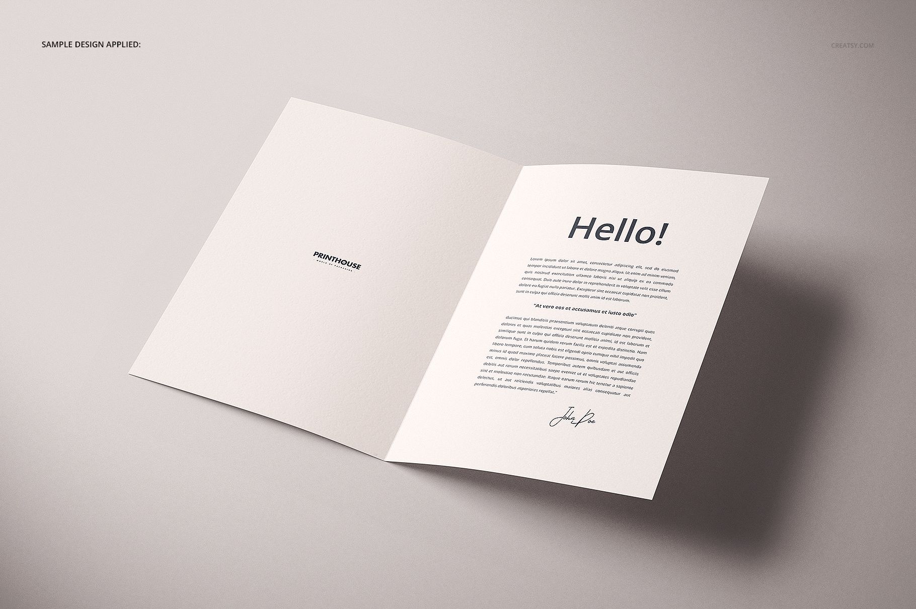 Folded A4 card mockup displayed open on a light surface, showing printed text and a minimal design inside.