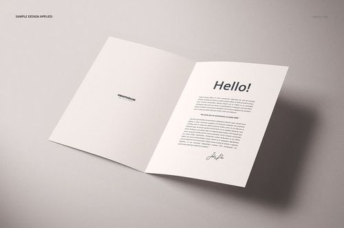 Folded A4 card mockup displayed open on a light surface, showing printed text and a minimal design inside.