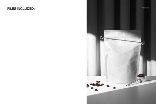 Coffee pouch mockup with metal scoop and beans, dramatic curtain shadows, and soft spotlight on a white table.