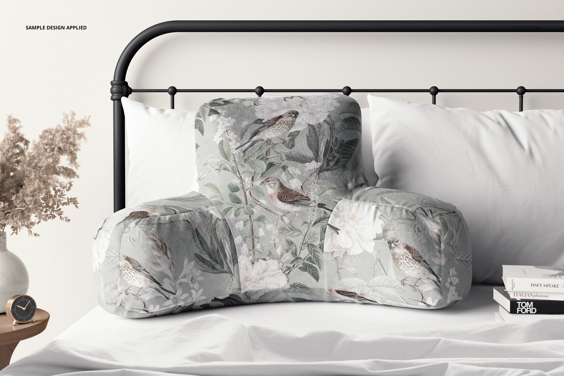 PSD mockup of a reading pillow displaying a botanical and bird design, placed on a neatly made bed in a calm room.