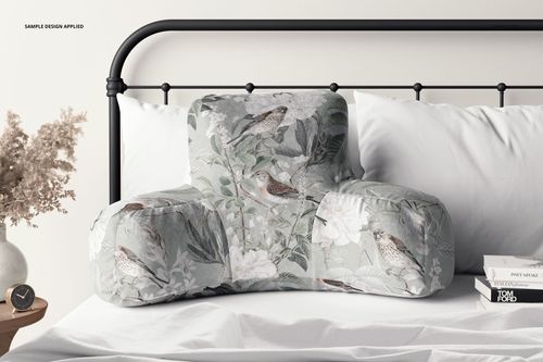 PSD mockup of a reading pillow displaying a botanical and bird design, placed on a neatly made bed in a calm room.