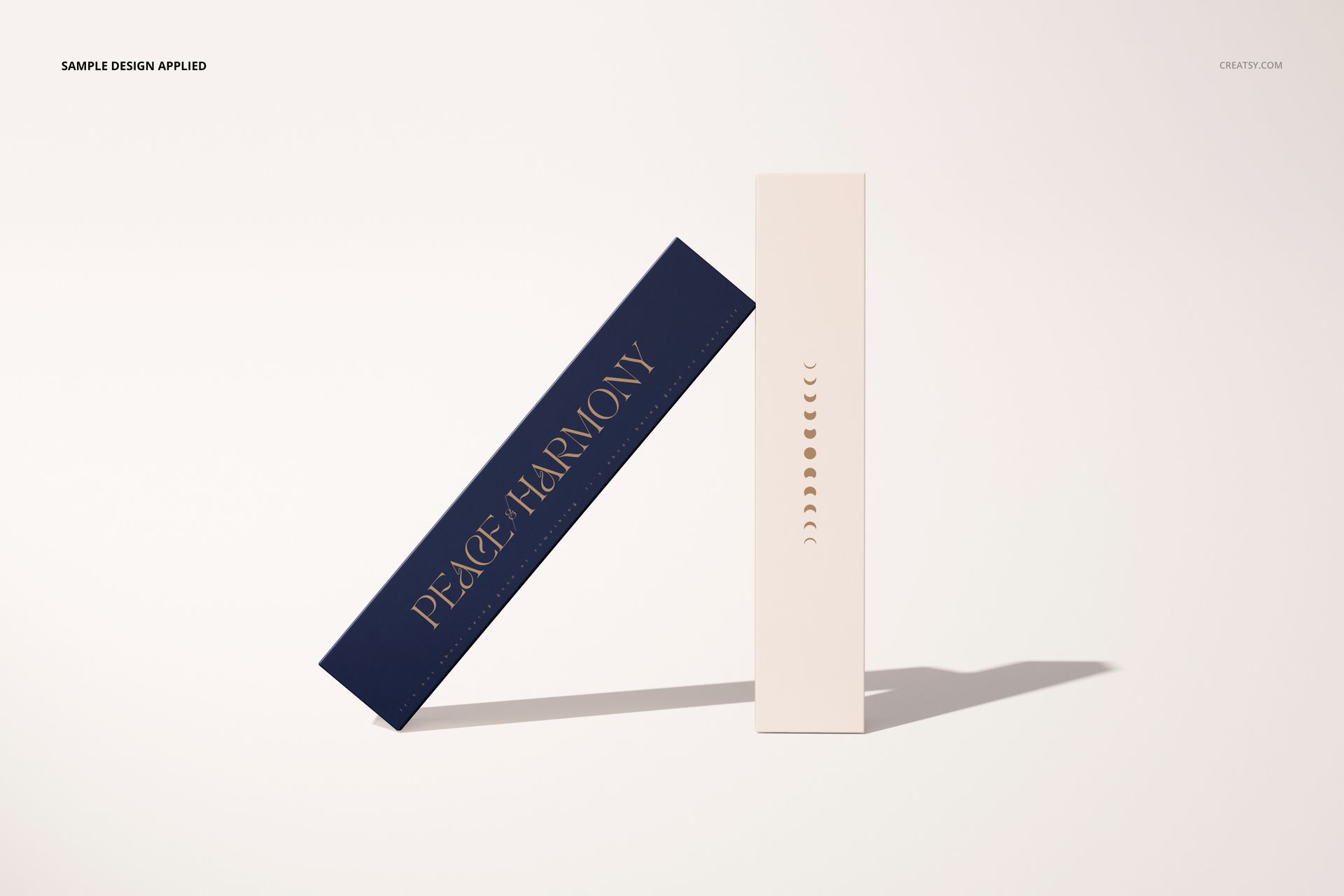 Yoga mat mockup featuring a rectangular mat with dark blue color and gold text, leaning against a tall white box on a light background.