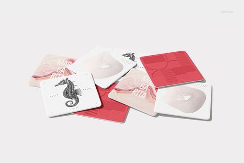 PSD mockup of square coasters with various abstract and text designs, displayed on a bright, minimal background.