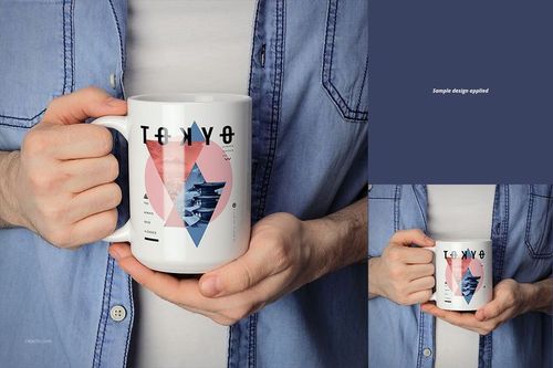 Person holding a white ceramic mug with a geometric Tokyo-themed design, shown from the front in a casual setting.