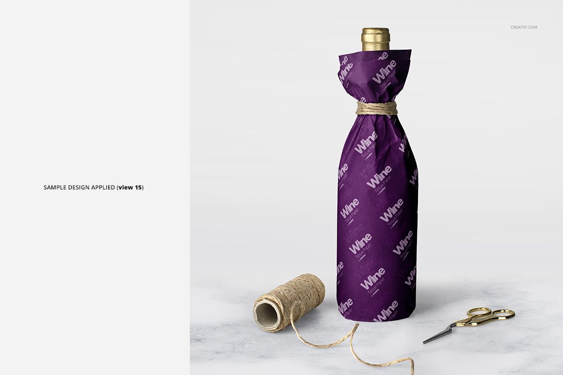 Wine wrapping tissue paper mockup featuring a bottle wrapped in purple paper with white lettering, twine, and props.