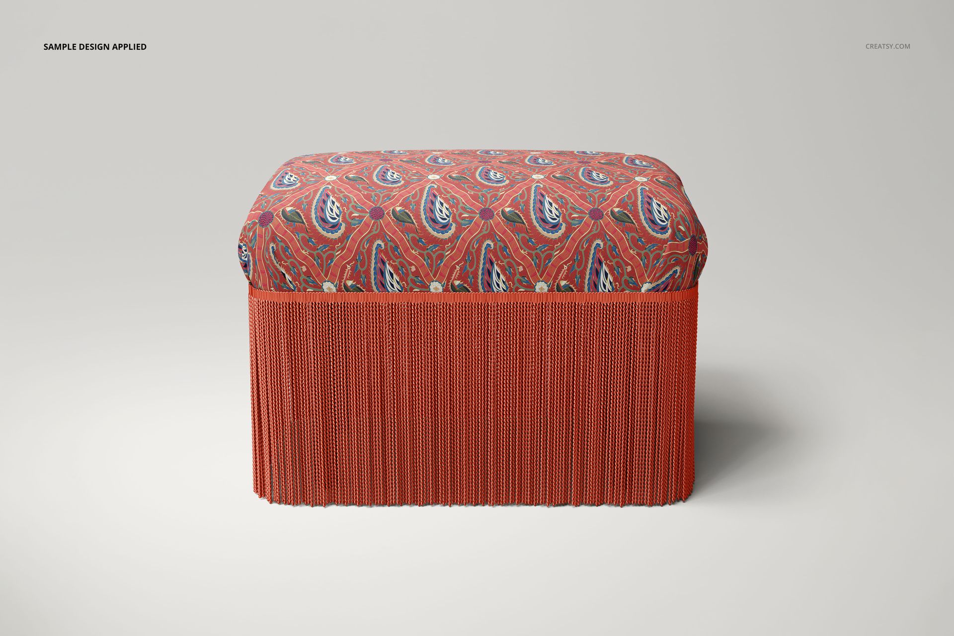 Rectangular velvet stool mockup with red patterned seat and matching bullion fringe, shown in a studio side view.