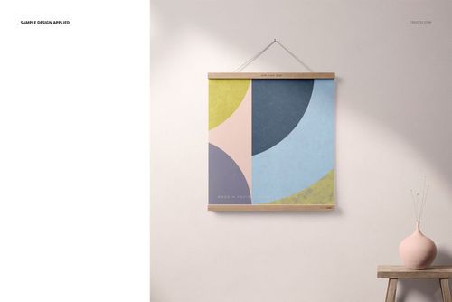 PSD mockup showing a wooden poster hanger with a colorful abstract print, next to a small vase on a minimalist shelf.