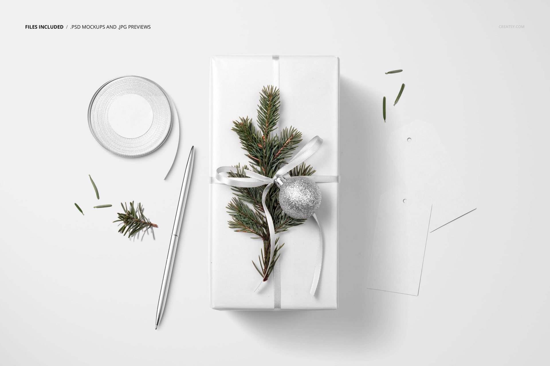 Christmas gift packaging mockup featuring white wrapping paper, ribbon, fir branches, and a metallic ornament from above.