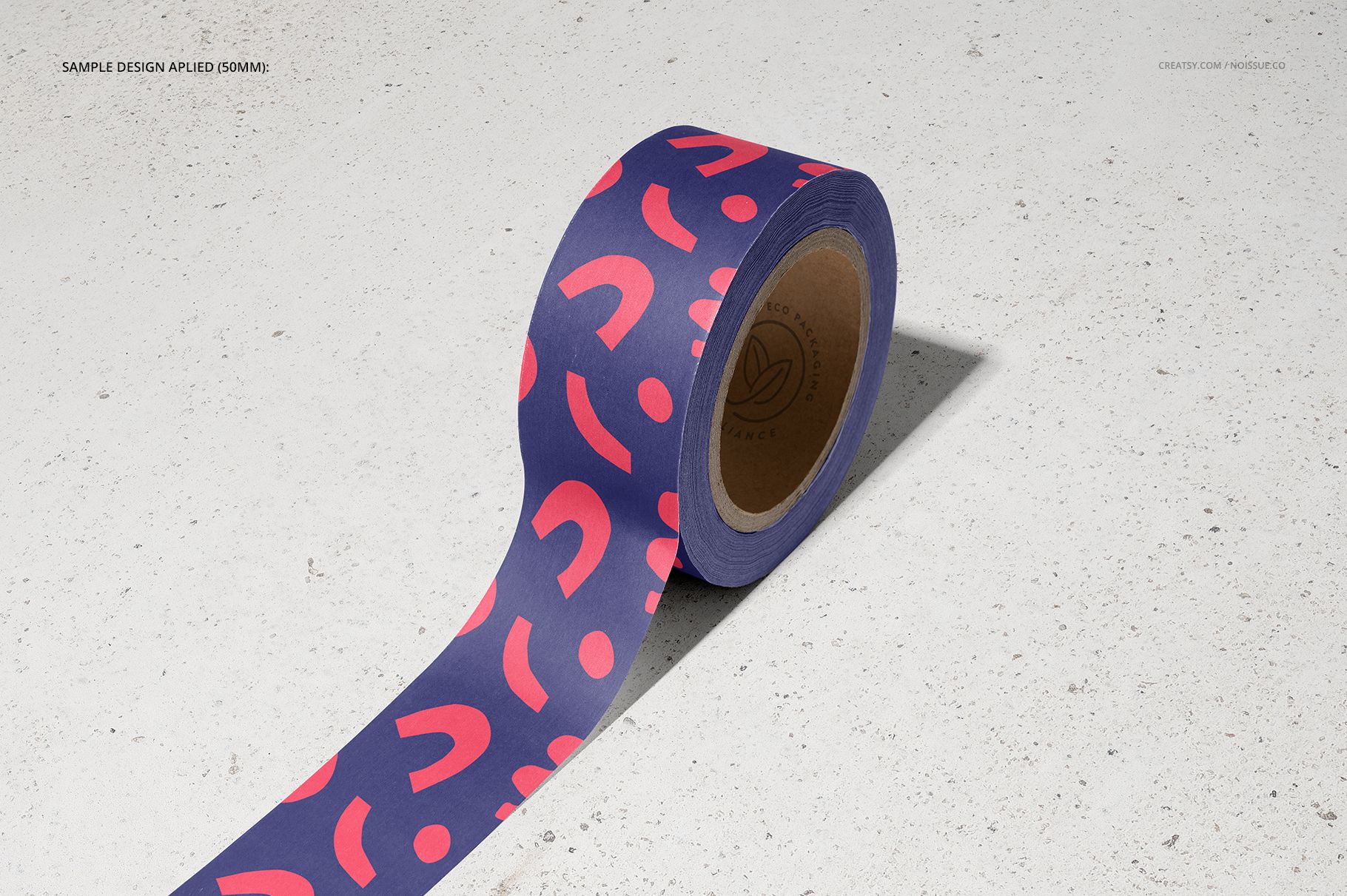 Noissue packing tape mockup with a vivid blue and pink design, photographed from a side view on a neutral surface.