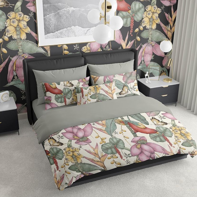 Bedroom scene bedding mockup featuring a bed with floral patterned duvet and pillows, set against a dark botanical wallpaper.