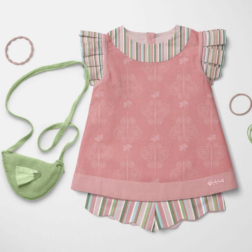 Baby blouse and shorts mockup set arranged flat on a white surface, featuring pink patterns and striped accents.