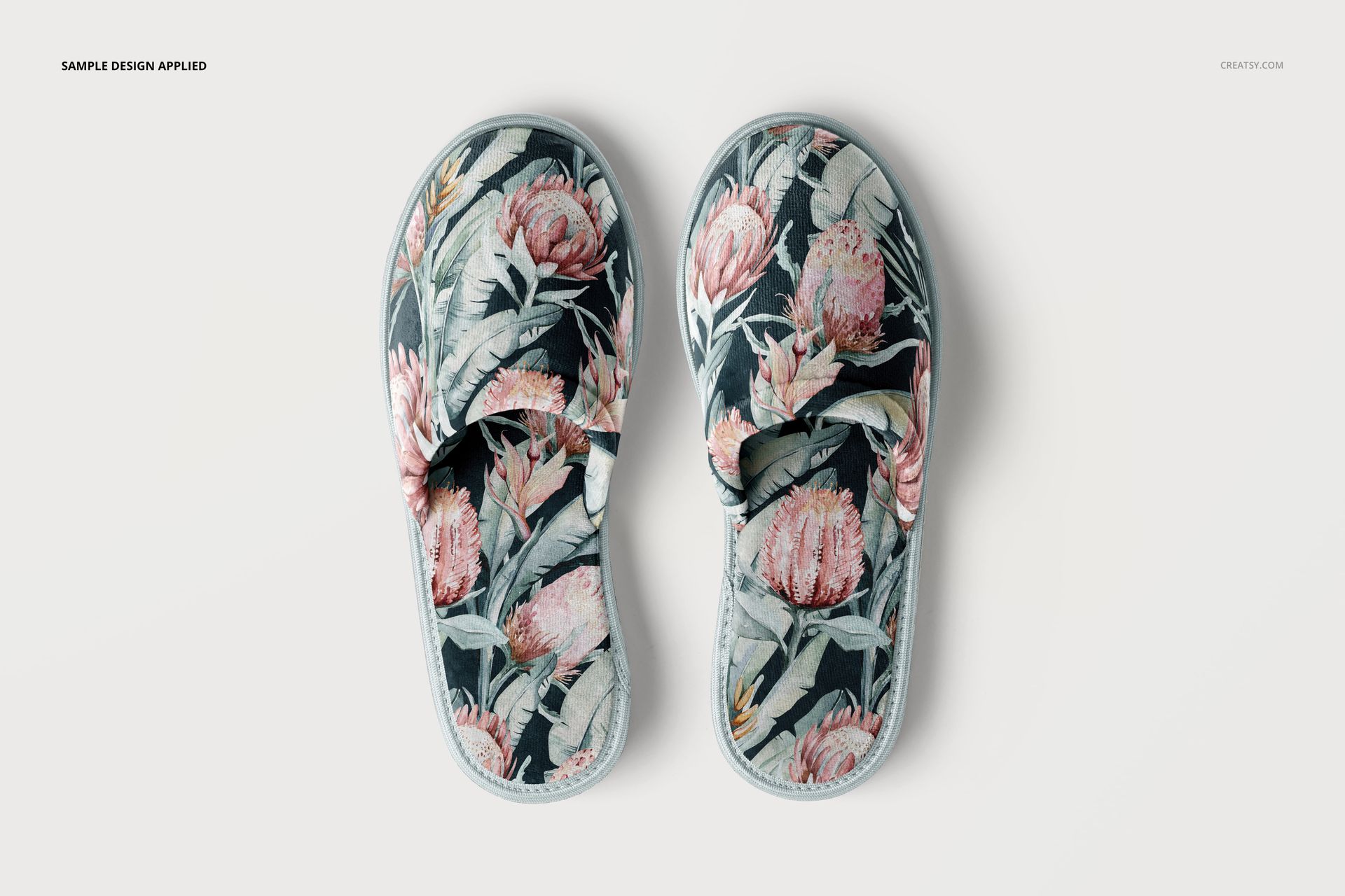 Home slippers mockup featuring a botanical design with large pink flowers and green leaves, viewed from above.