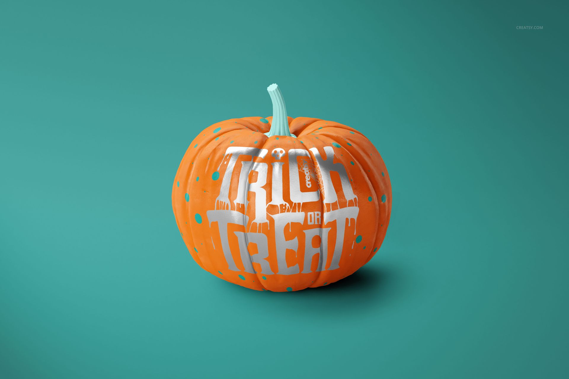 Halloween pumpkin PSD mockup featuring bold white lettering and blue spots, displayed against a teal backdrop.