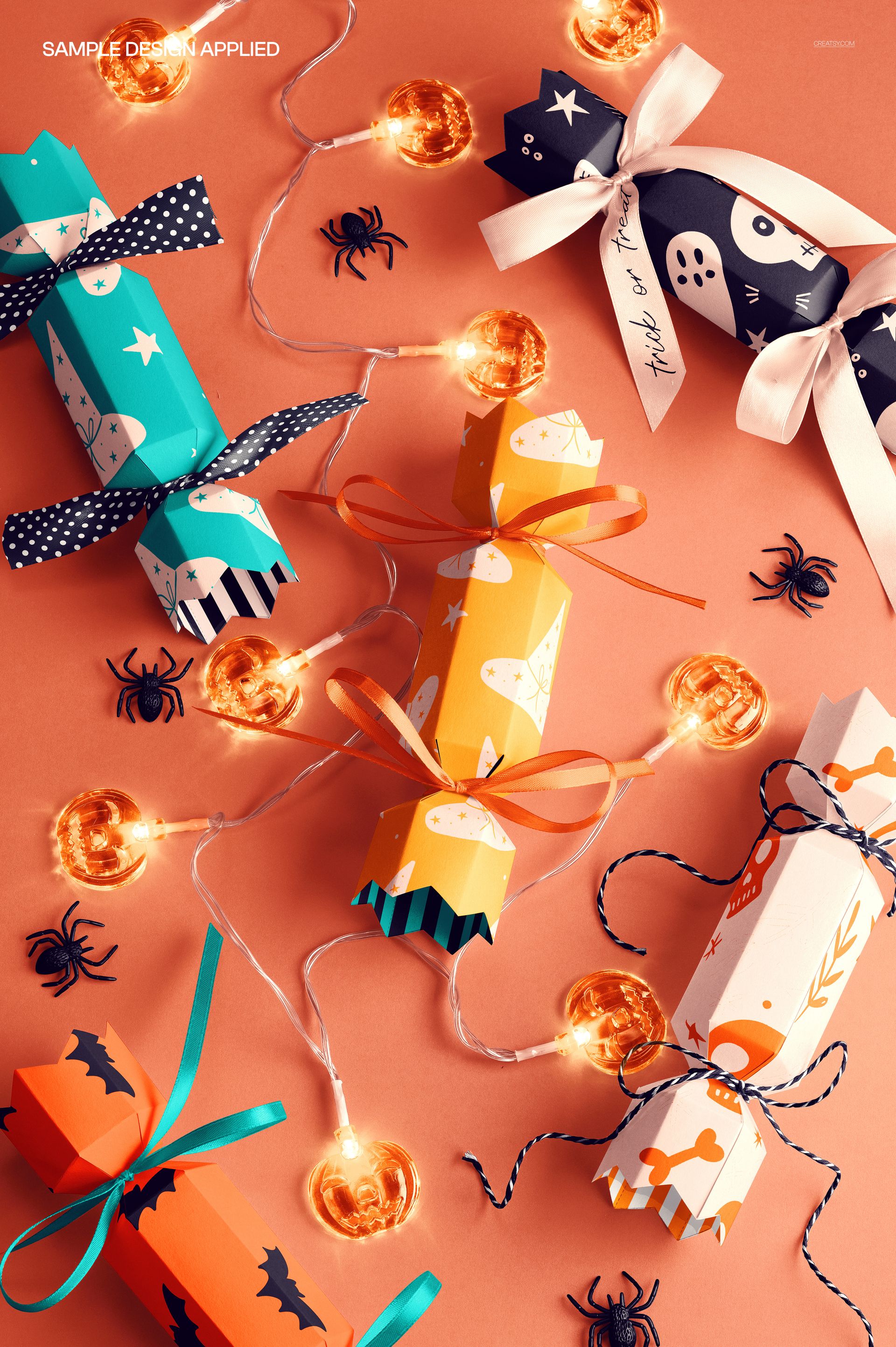 Halloween party cracker packaging mockup featuring colorful crackers with festive patterns on an orange surface.