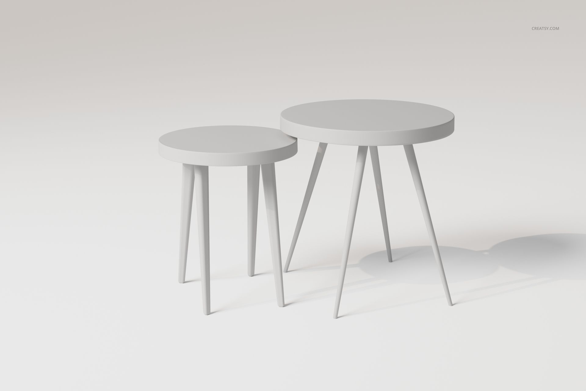 Two round nesting tables with minimalist design, light gray color, and angled legs, shown on a plain background.
