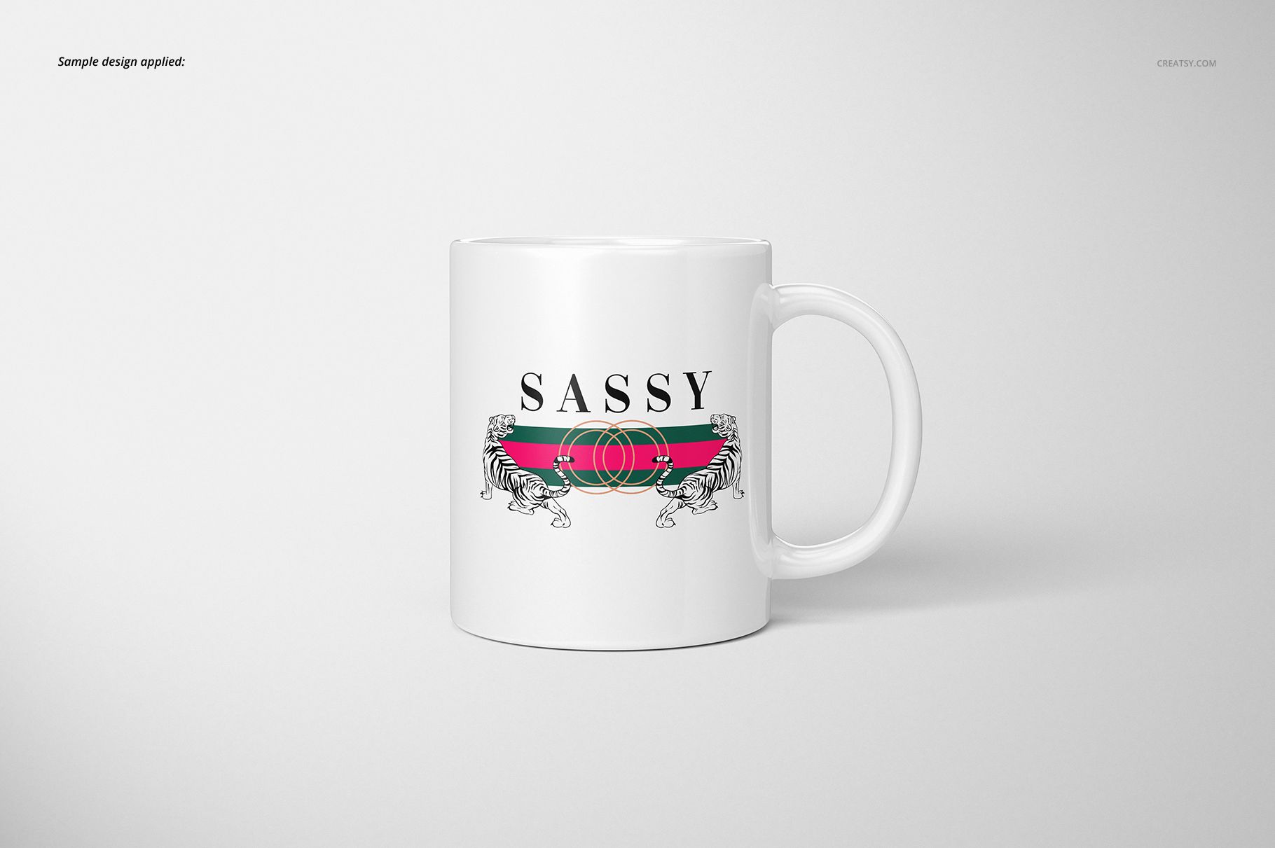 White ceramic 11oz mug with a centered design featuring two tigers, a red and green stripe, and the word SASSY.