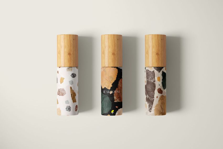 Cosmetic mailing box mockup featuring three upright cylindrical bottles with wooden caps, each with a different stone-inspired pattern.