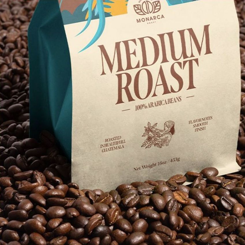 Coffee bag mockup featuring a medium roast package standing upright on a surface covered with roasted coffee beans.