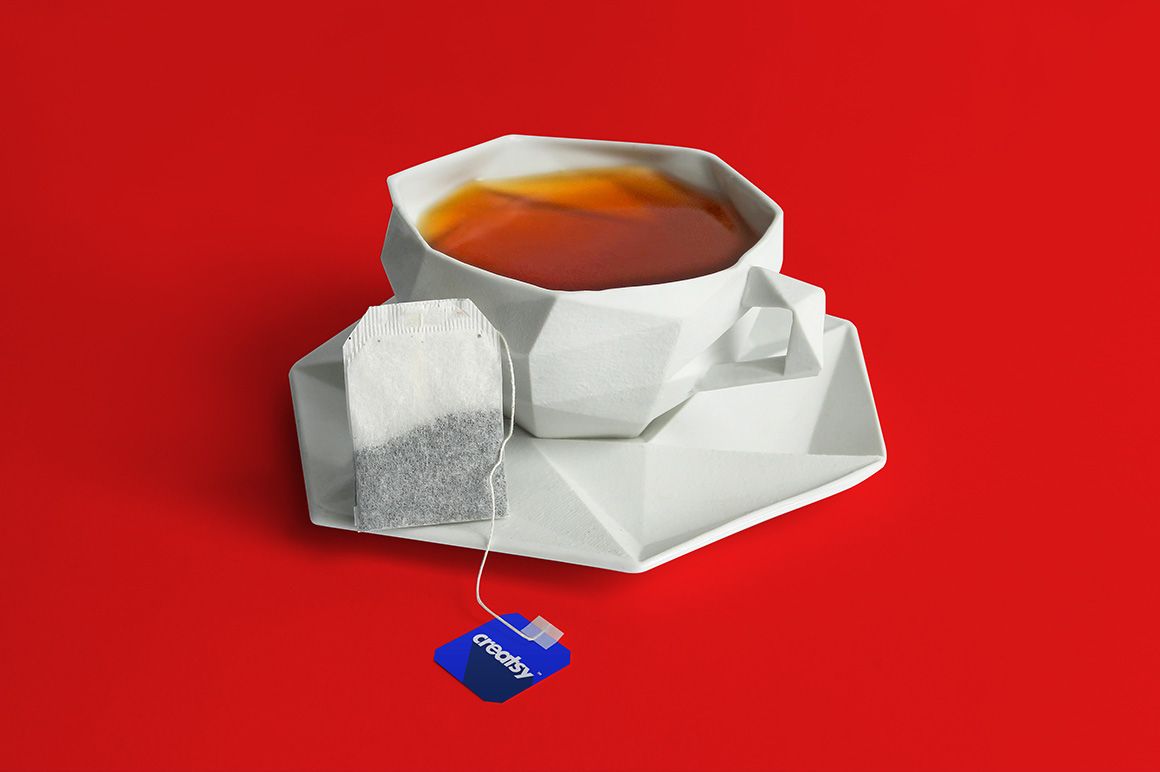 Modern white tea box and label mockup set with tea bag, shown on a bold red surface, front perspective.