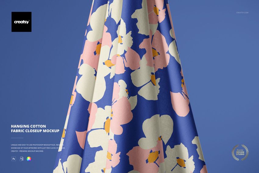 PSD mockup displaying hanging cotton fabric with a colorful floral pattern, viewed from the front at an angle.