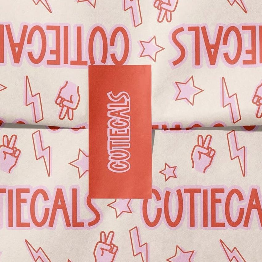 Wrapping paper mockup featuring repeated pink and red text, lightning bolts, stars, and peace hand signs with a matching sticker.