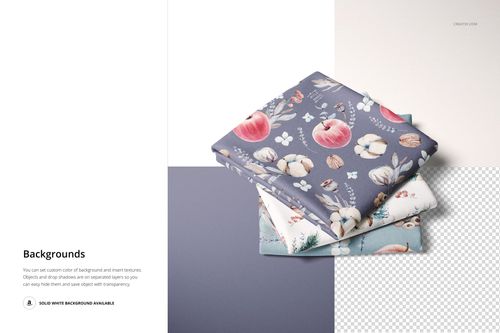 PSD mockup of stacked folded fabrics with decorative prints, presented on a partially transparent and solid colored surface.