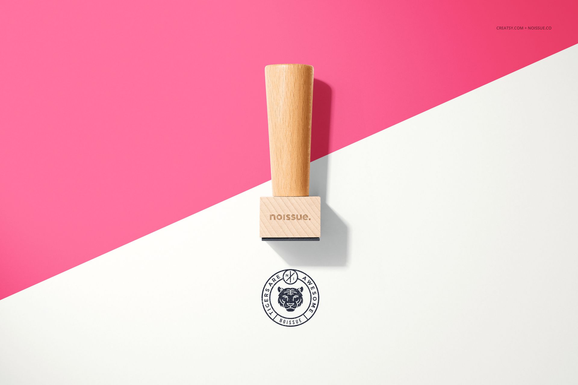 Single wooden stamp mockup displayed upright on a split pink and white surface with a stamped circular logo below.