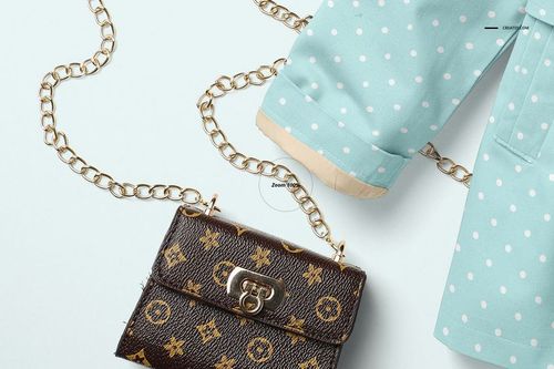 Light blue baby coat with white polka dots and beige cuffs, shown with gold chain and small patterned purse.