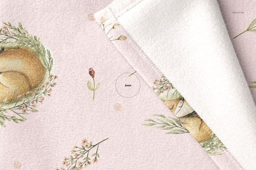 Soft fleece baby blanket mockup with a pastel pink surface, featuring animal and floral illustrations, shown in close-up view.