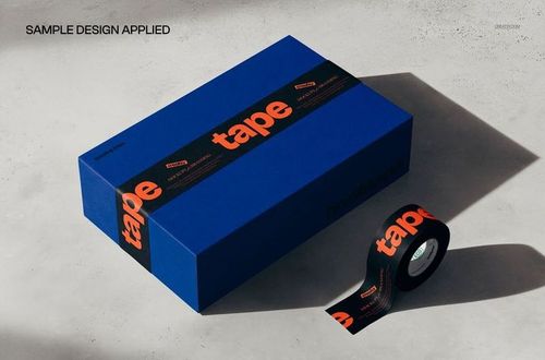 PSD mockup of a blue packaging box closed with black tape, orange text design, and a matching tape roll in the scene.