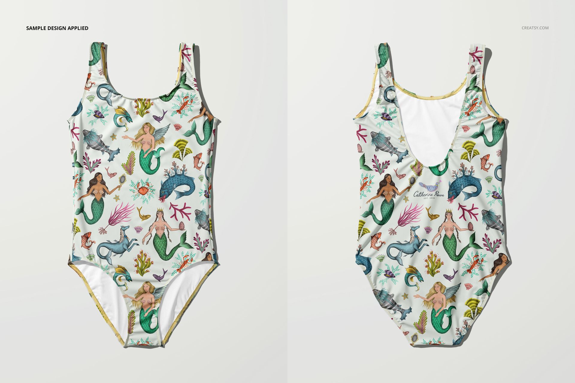 PSD mockup showing a one-piece swimsuit laid flat with playful mermaid and sea creature illustrations in pastel colors.
