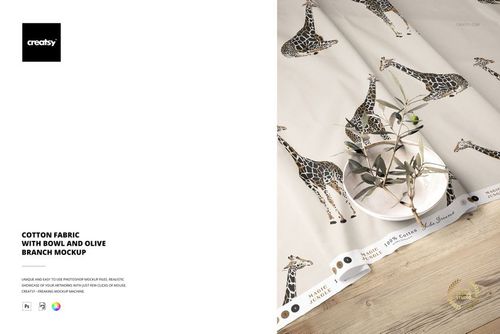 PSD mockup showing cotton fabric with animal print, ceramic bowl, and olive branch arranged on a tabletop.