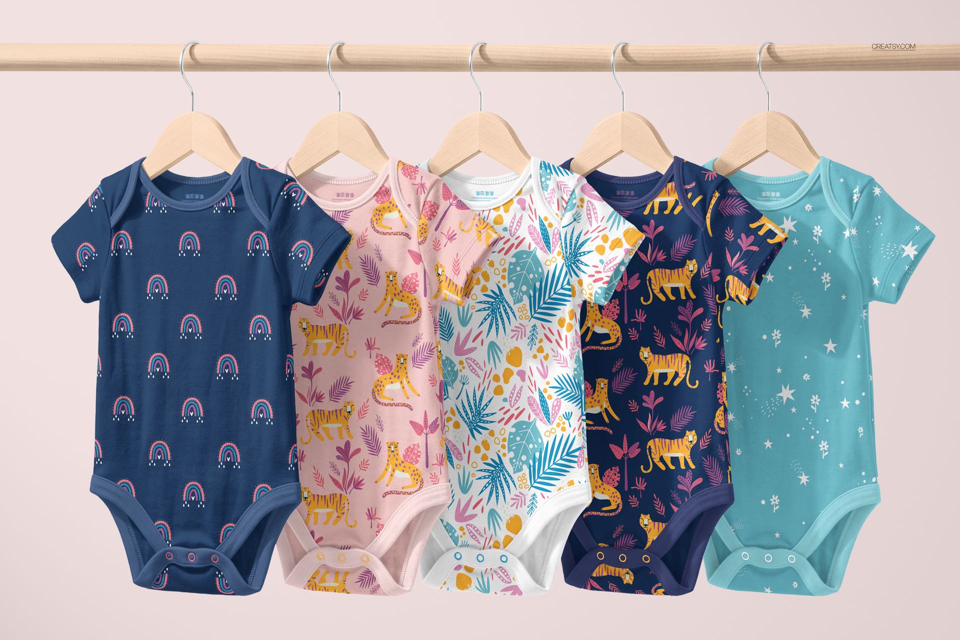 Row of baby bodysuits in various colors and playful prints displayed on hangers, front view, mockup scene.