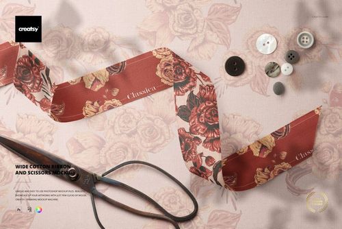 PSD mockup showing a wide cotton ribbon with red and beige flowers, accompanied by sewing tools on a soft fabric base.