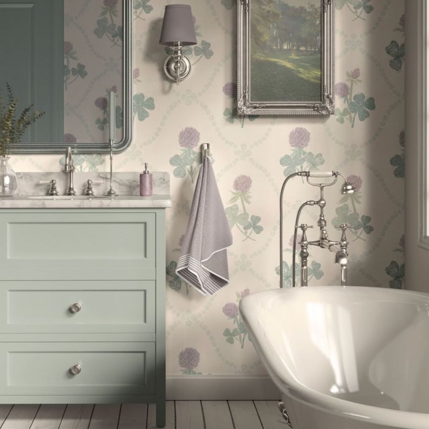 Victorian bathroom wallpaper mockup showing a vintage-style bathroom with clover patterned wallpaper, a pastel vanity, and a clawfoot tub.
