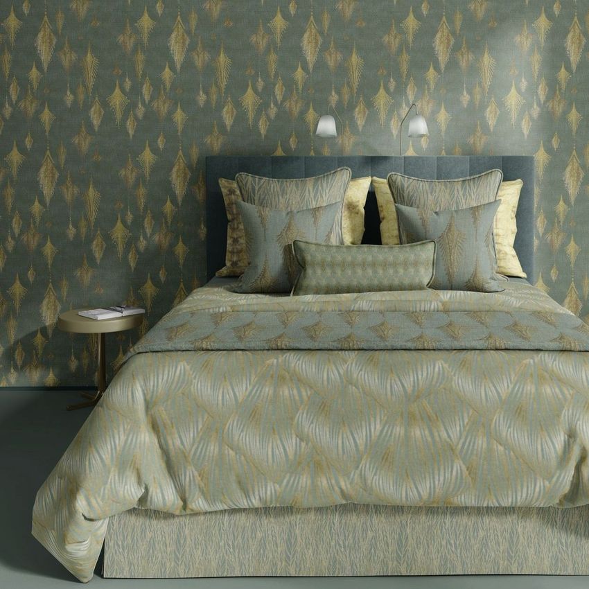 Bedroom scene bedding mockup showing a neatly made bed with patterned pillows and comforter, matching the wallpaper behind.