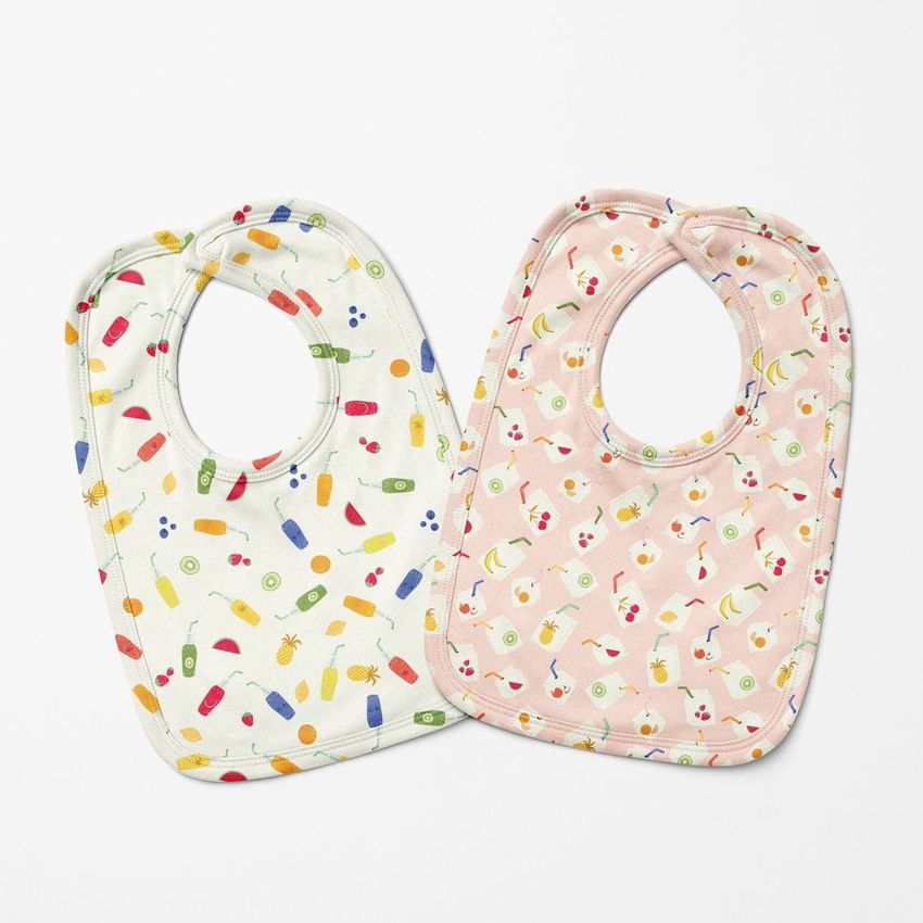 Two velcro fastening bibs mockup displayed on a white background, one with colorful food patterns and one with a pink animal print.