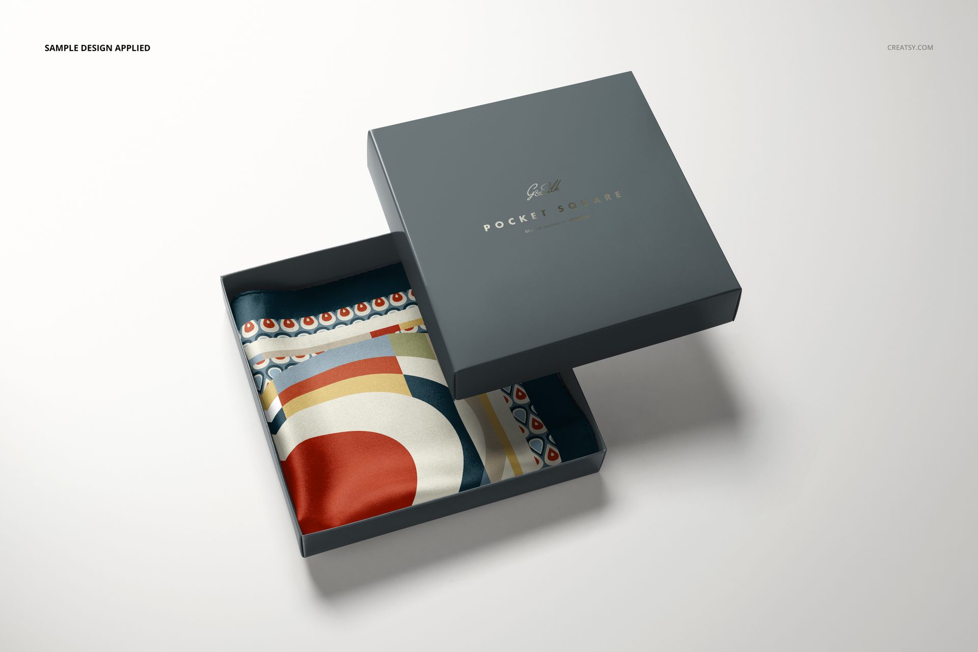 PSD mockup of a fashion accessory set with a folded pocket square in a sleek box, geometric design visible.