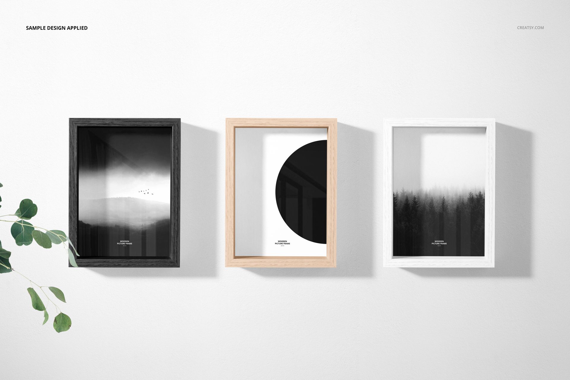 Mockup of three rectangular picture frames in varied wood tones, showcasing monochrome and abstract prints in a bright room.