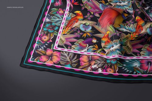 Lightweight cashmere scarf mockup featuring a vibrant tropical bird and floral pattern, shown from above on a dark surface.