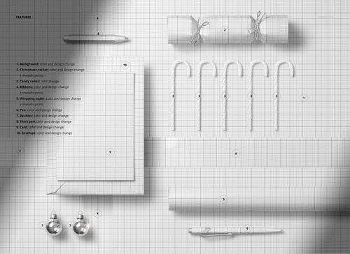 Top view of a Christmas greeting card mockup scene with cracker, candy canes, ribbon, and ornaments on grid paper.