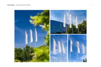 PSD mockup of rectangle flag banners on poles, photographed outdoors with trees and a modern building in the background.