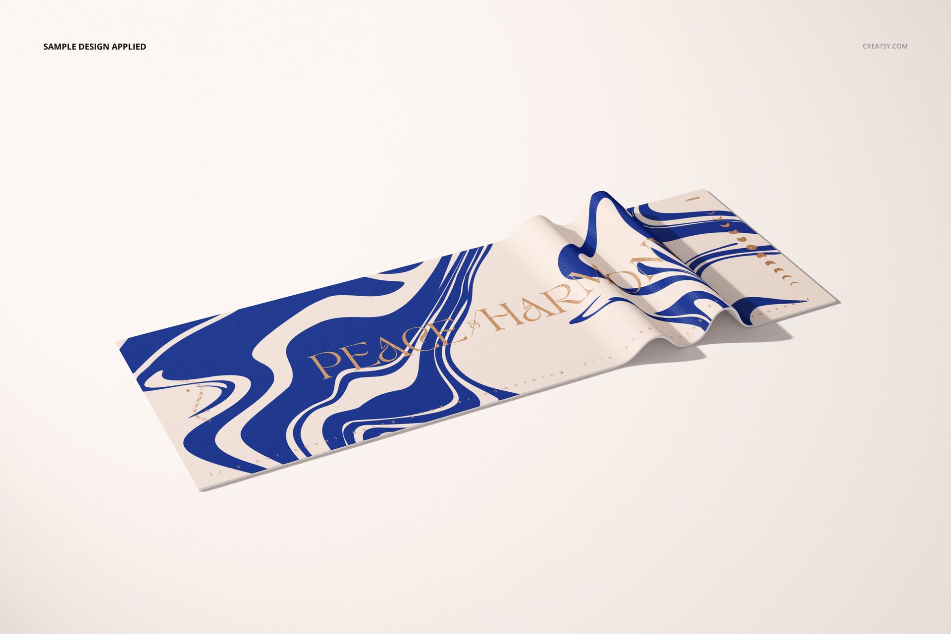 Yoga mat mockup featuring bold blue and white swirls and gold text, displayed on a neutral surface in perspective view.
