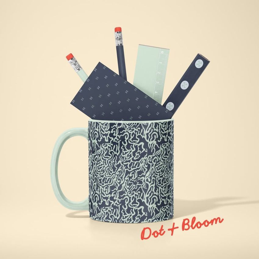 Mug mockup with abstract dark blue pattern, holding pencils, rulers, and stationery on a beige background. Text overlay in red.