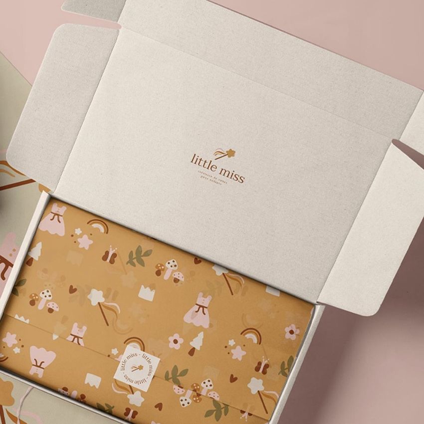 Mailing box mockup with an open lid, revealing patterned tissue paper in warm brown tones and a small logo inside the lid.