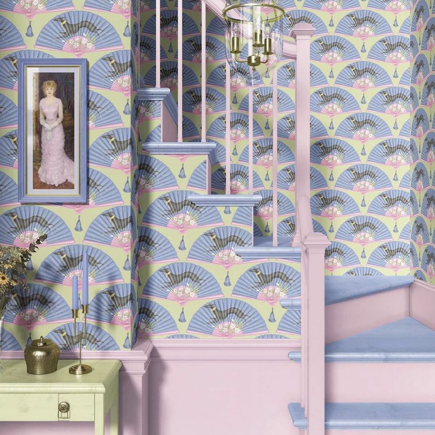Traditional staircase mockup featuring pastel wallpaper with fan patterns, blue steps, and decorative objects on a side table.