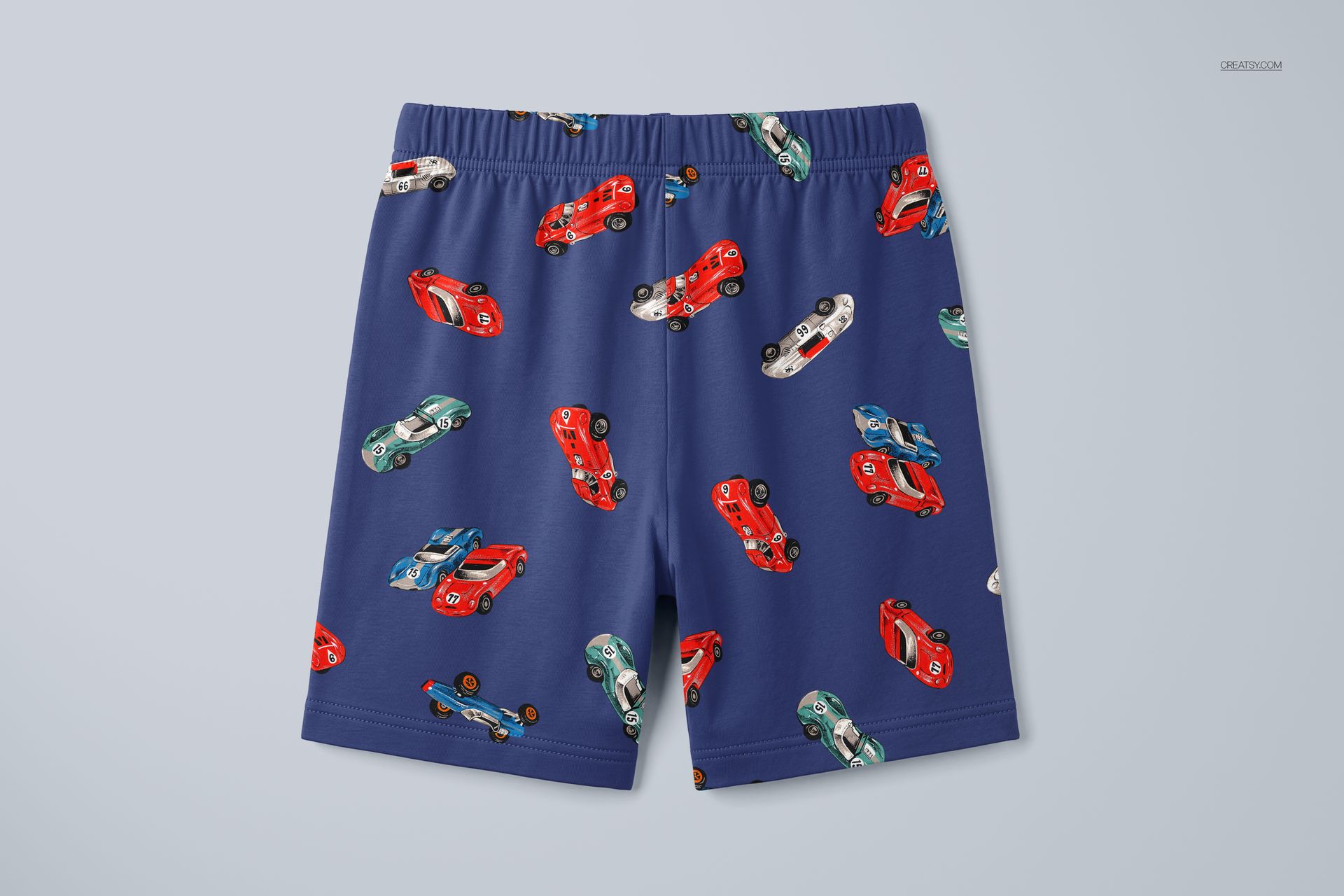 PSD mockup of children's short pyjamas with red, green, and white cars on a blue fabric, front perspective.